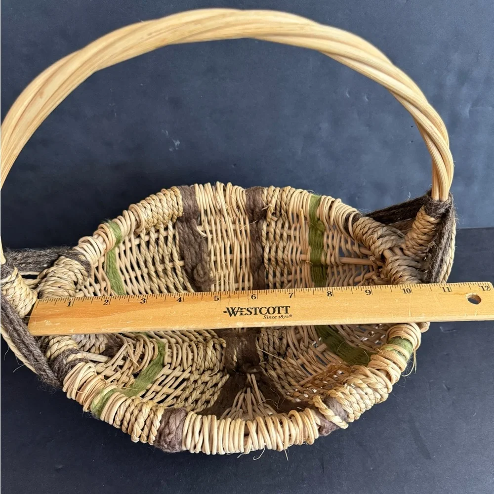 Vintage handwoven basket with brown and green yarn details and eye of God.